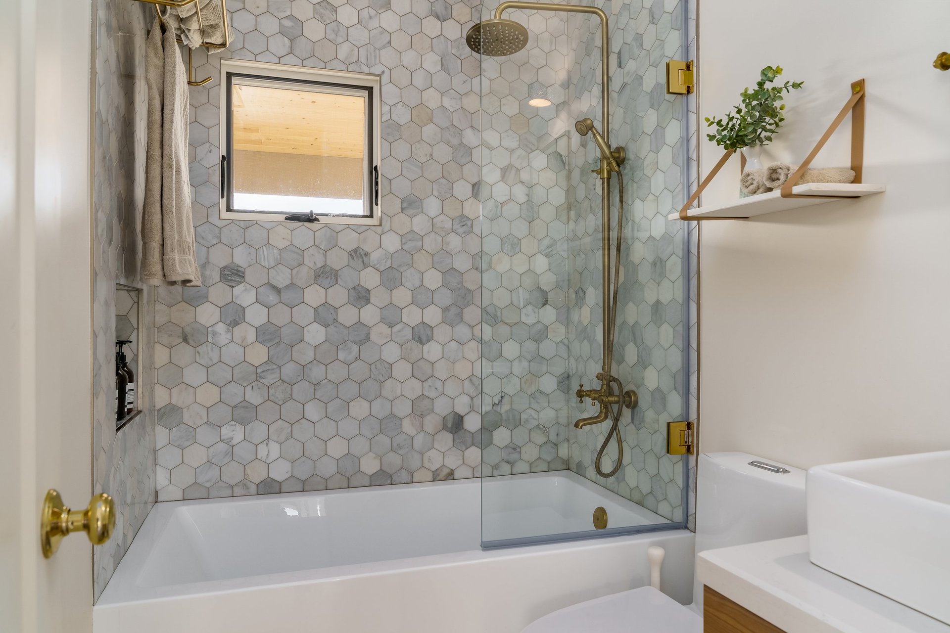 Modern bathroom with hexagonal tile and gold brass fixtures