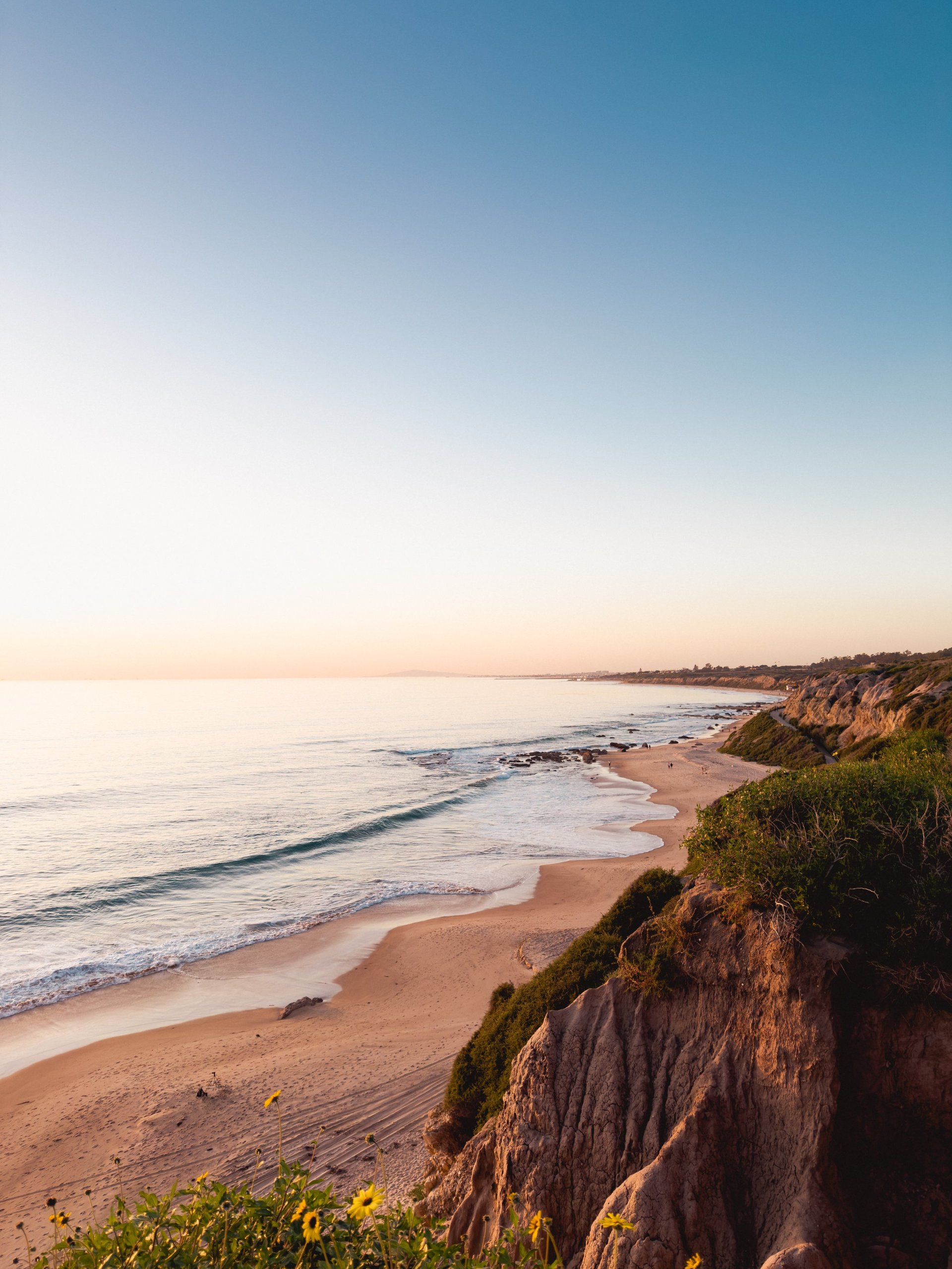High angle view of California coastline with waves washing up to sandy beach