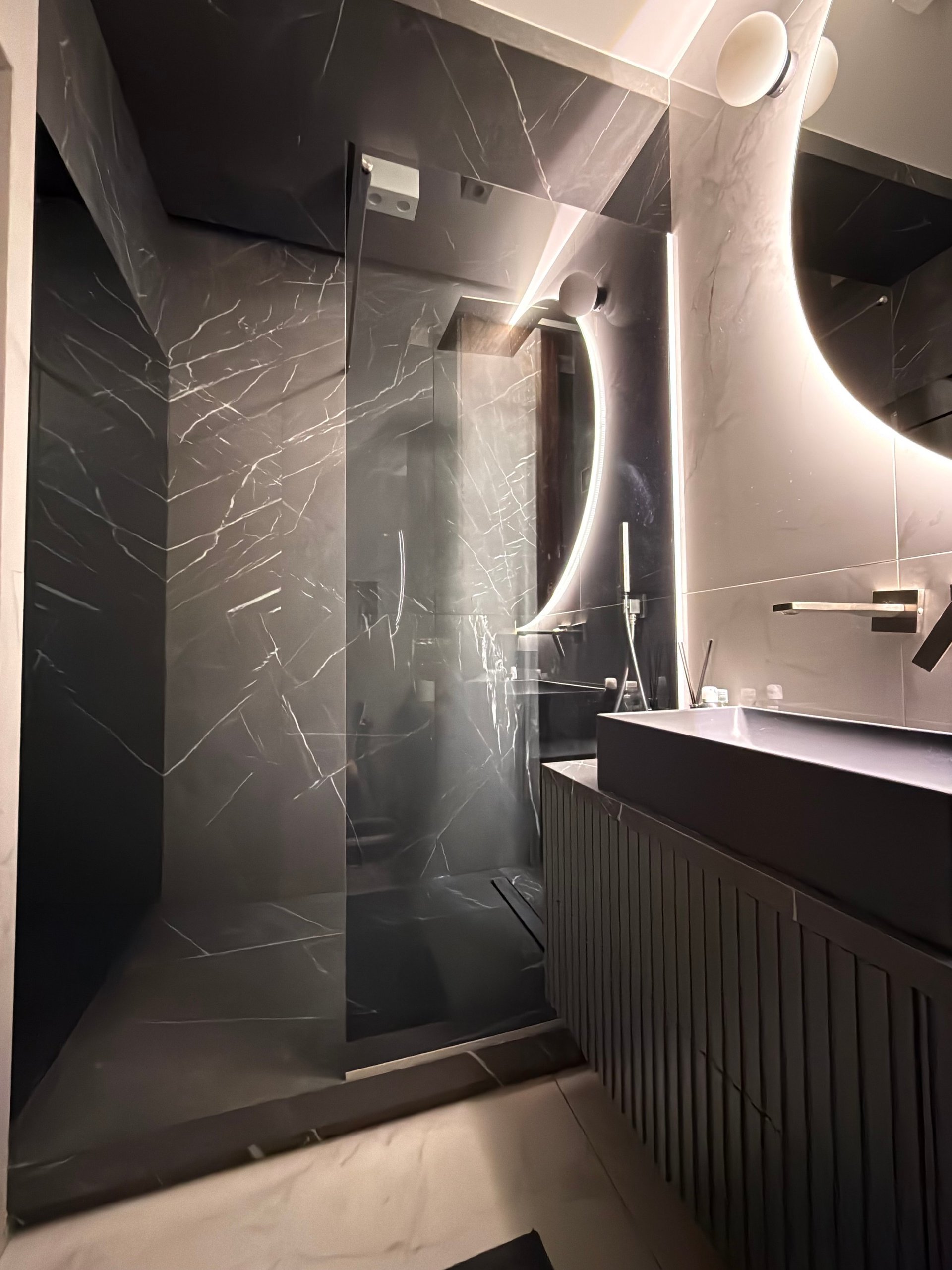 Luxury Modern Bathroom with Marble Shower and Glowing Round Mirror
