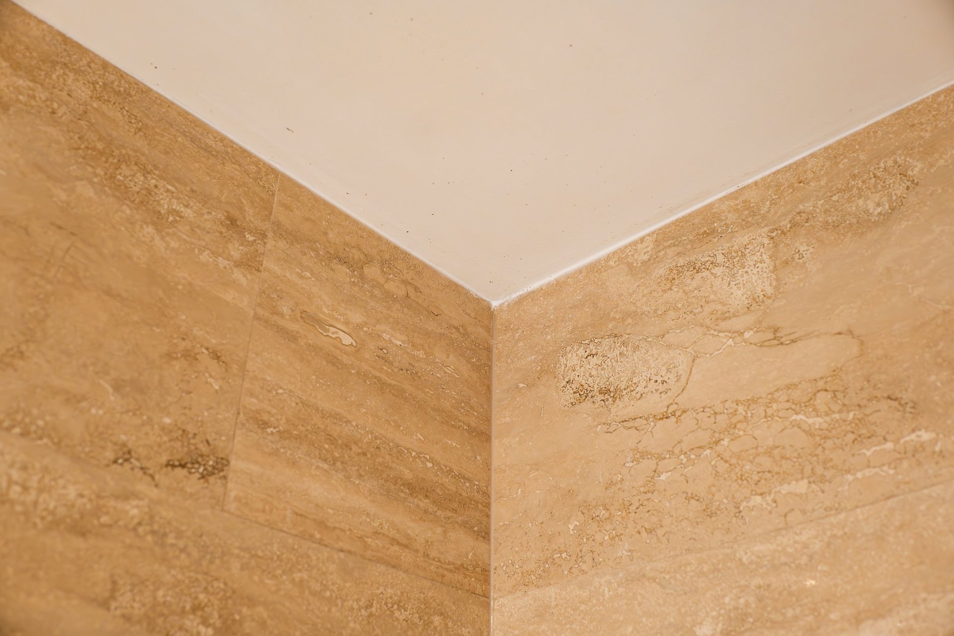 Detailed shot of a room corner featuring high quality travertine tiles with natural textures and patterns