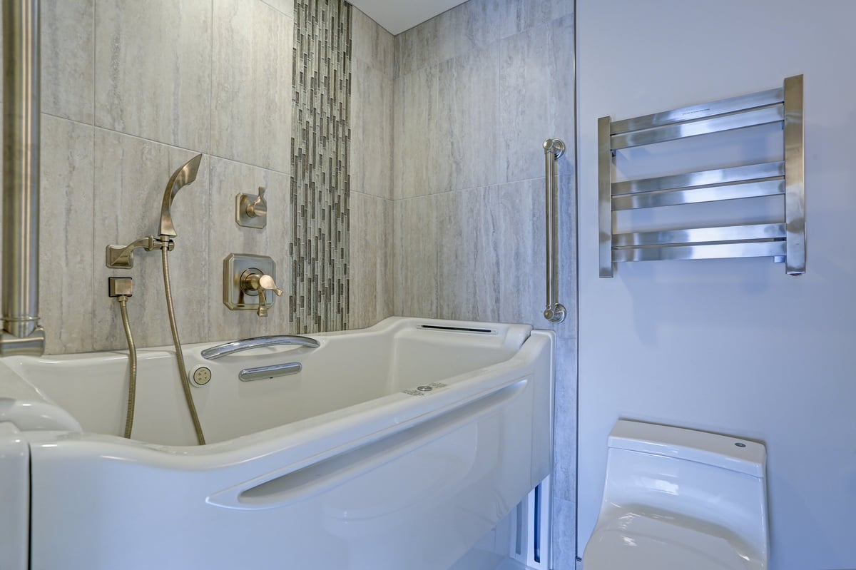 Contemporary bathroom design with luxury walk-in bathtub flanked by subway tiles and glass mosaic accents